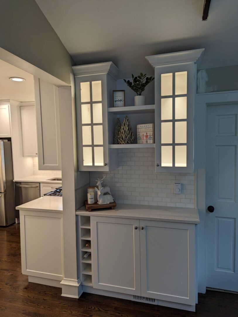 A kitchen with white cabinets and shelves in it