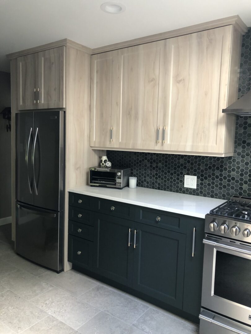 A kitchen with black cabinets and white counters.