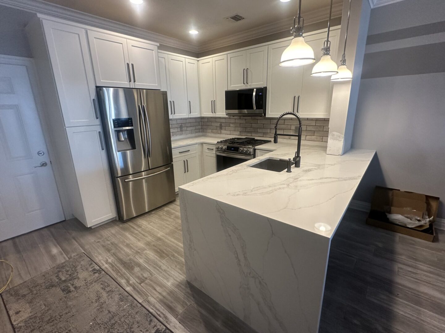 A kitchen with white cabinets and stainless steel appliances.