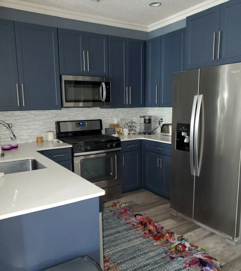 A kitchen with blue cabinets and white counters.